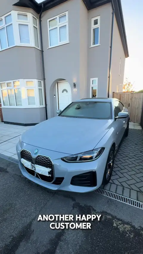 Silver BMW coupé on a house driveway with its front bumper masked for a paint repair