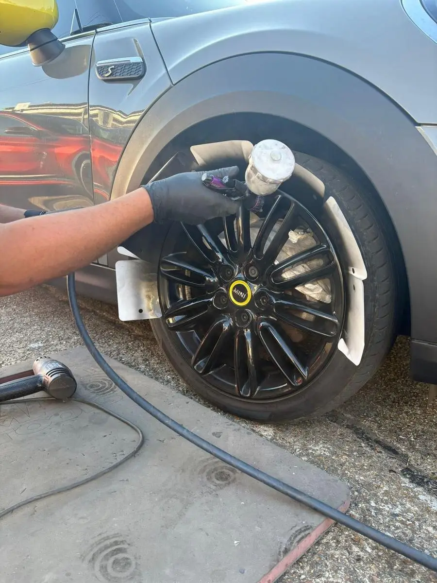 Mini Cooper wheel being prepared and primed during repair